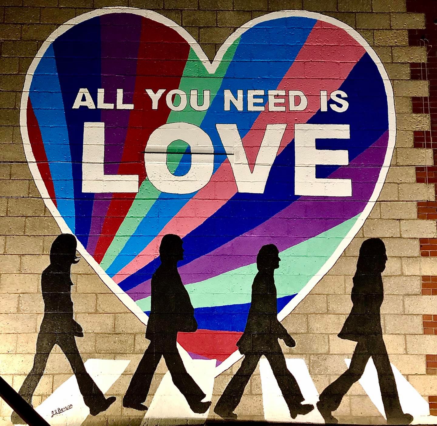 mural of large colorful heart and silhouettes of the beatles walking
